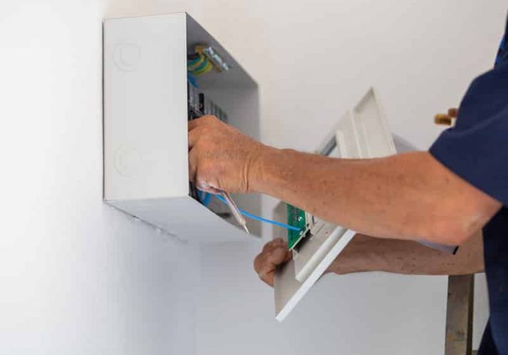 Indoor electric circuit control box and a technician — Electricians in Buderim, QLD